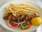 Chicken souvlaki with french fries and vegetables.