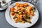 Chicken steak with asparagus and shrimp, fried halved potato, vegetable on plate