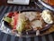 Chicken steak with white sauce and mashed potatoes and steamed vegetables in a sizzling tray food photography in restaurant