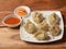 Chicken steam momo. Nepalese Traditional dish Momo stuffed with chicken and then cooked and served with sauce over a rustic wooden