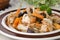 Chicken stew with carrots and prunes on a plate, closeup, select