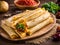 Chicken tamales wrapped in corn husks in a stack on a cutting board