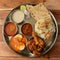 Chicken Thali from an indian cuisine, food platter consists Chicken fry,Boiled egg curry, lentils, chicken biryani,roti and onions