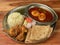 Chicken Thali from an indian cuisine, food platter consists Chicken fry,Boiled egg curry, lentils, jeera rice, and onions.