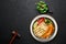 Chicken Thukpa in black bowl at dark slate background. Chicken Thukpa is Tibetan cuisine noodle soup