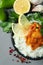 Chicken tikka with ingredients on gray background