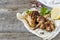 Chicken wings baked on grill with fresh herbs, lemon on wooden background.