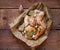 Chicken wings and knives in spices with garlic and bay leaf on a craft bag are on the table