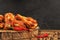 Chicken wings with red hot chili peppers and peppercorn on wooden table.