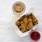 Chicken wings with sauce, cold beer over white wooden surface, top view. From above, flat lay