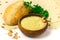 Chickpea flour in ceramic bowl, chickpea beans, homemade bread, parsley bunch on sheet of pita bread