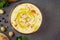 Chickpea hummus in a bowl, ingredients, pita bread on gray background.