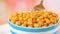 Chickpeas, garbanzo beans, in bowl closeup with spoon.