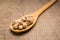 Chickpeas legume. Spoon and grains over wooden table.