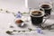 Chicory beverage in two glass cups, with concentrate and flowers on grey background. Healthy herbal beverage, coffee substitute,
