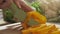 Chief cutting yellow peppers on a wooden board with a professional knife and a great skill. Scene. Close-up of chief