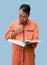 The chief mechanic in an orange uniform holding big book. Stand and read the maintenance manual carefully. Portrait with studio