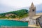 Chiesa San Pietro catholic church with bell tower, Lord Byron Parque Natural park, Palmaria island with green trees, cliffs, Porto