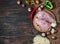 Chiken breast On a cutting board with herbs different fruits and vegetables on rustic wooden background top view