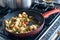 Chiken meat and vegetables cooking in red frying pan