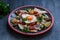 Chilaquiles Mexican tortilla with tomato salsa, chicken and egg close-up on a plate. Horizontal view from above