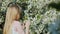 The child admires the flowering tree, the view from behind.