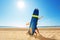 Child and adult behind surf board on a beach pose