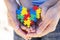 Child and adult hands holding colorful heart. World autism awareness day concept