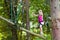 Child in adventure park. Kids climbing rope trail.