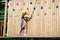 Child in adventure park. Kids climbing rope trail.