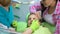Child afraid of dental examination, doctor and parent calming little girl