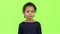 Child of an african american girl is sad. Green screen . Slow motion