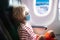 Child in airplane in face mask. Virus outbreak