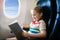 Child in airplane. Fly with family. Kids travel