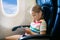 Child in airplane. Fly with family. Kids travel.pl