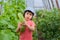 A child in amazement holding a large giant cucumbers in the greenhouse.