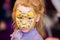 Child animator, artist`s hand draws face painting to little girl. Child with funny face painting. Painter makes yellow leopard at