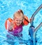 Child with armbands in swimming pool