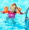 Child with armbands in swimming pool