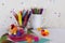 Child arts and craft work station with colored pencils, colourful feathers, pom poms and paper