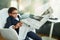 Child as a businessman reads newspaper in the office