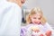 Child as a patient looks at a denture model