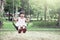 Child asian girl having fun to play swing in playground