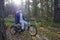 Child autistic with disabilities on a tricycle with management for mom, in a blue cap and jacket in the Park for a walk