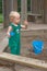 Child baby in sandbox playing with beach toys. Girl toddler watching exploring sand on hands. Kid have fun on playground. Summer