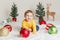 Child baby in yellow sweater clothes sitting on white fluffy rug celebrating Christmas or New Year