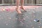 Child with bare feet bouncing on trampoline covered in confetti