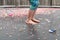 Child with bare feet bouncing on trampoline covered in confetti