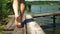 Child with bare feet walks along a wooden bridge on the river bank in summer