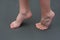 child is barefoot on mat. child does an exercise for feet, standing on tiptoes. Prevention of flat feet in children.